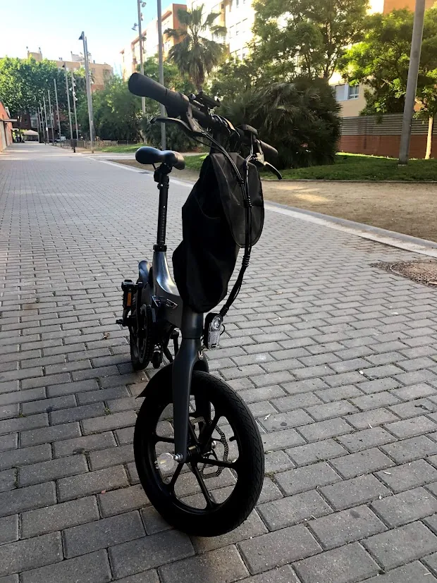 Bicicleta plegable negra con bolsa en manillar
