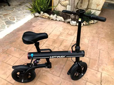 Patinete eléctrico negro con asiento, en suelo de baldosas rojas — foto 3