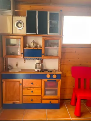 Cocina de juguete con electrodomésticos y un sillón rojo — foto 1